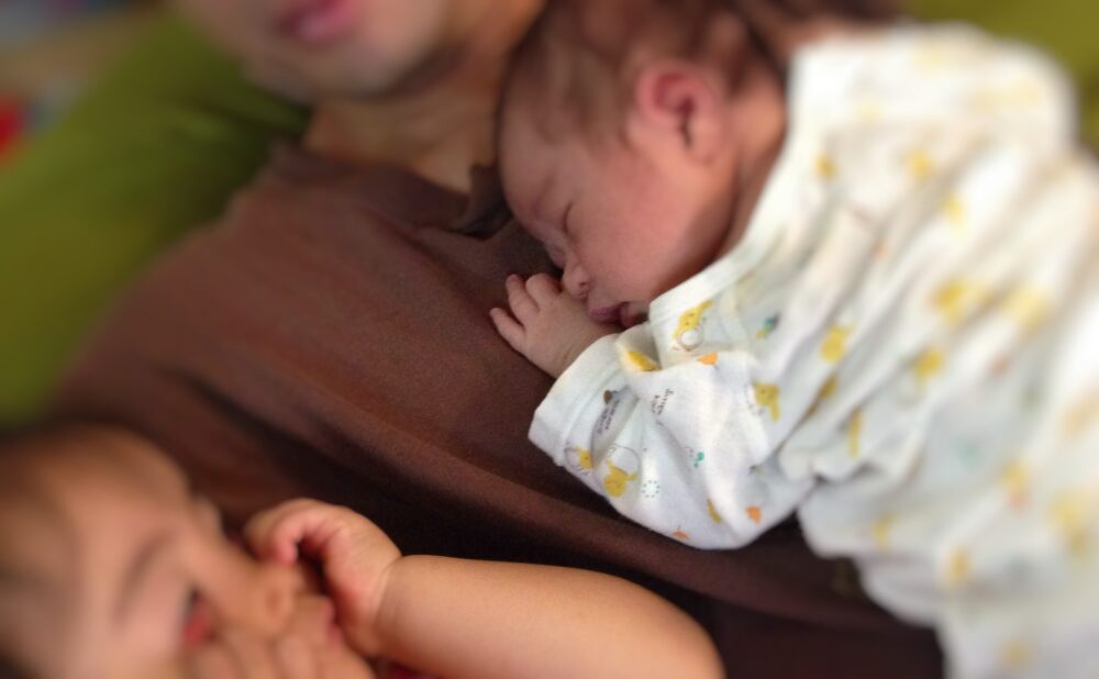 パパとお腹を密着させて寝る新生児