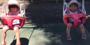 バケットシートブランコに赤ちゃんと子供が乗っているところ